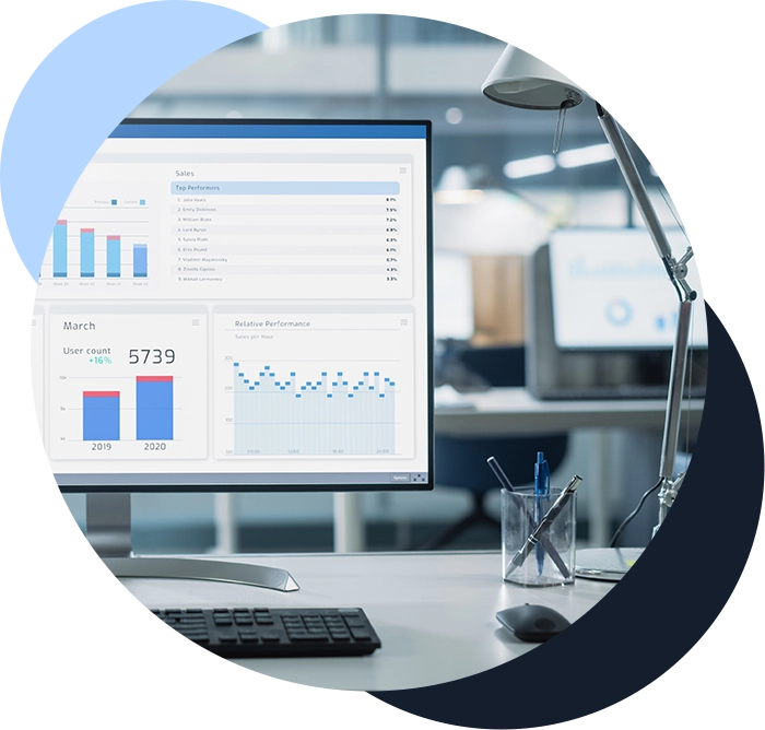 Color photo of a desktop computer with IT metrics and analytics displayed onscreen
