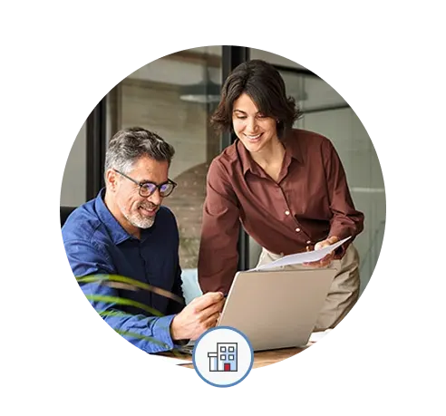 Miles IT referral program - people from the referring company look at a laptop screen together in an office